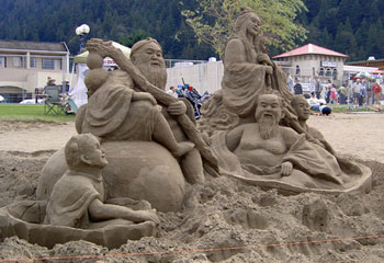 Sculpture of several smiling people sitting on the ground