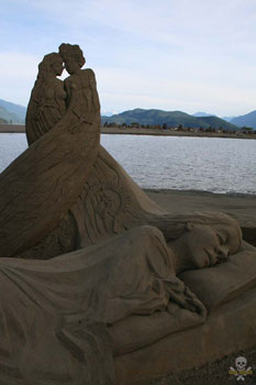 Sand Sculpture of a women sleeping, with an abstract man and women in the background