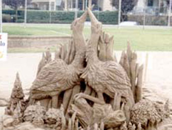 Carving featuring two birds looking skyward with their beaks touching