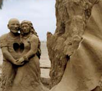 Sculpture of a man and woman holding hands with a heart carved in between them 