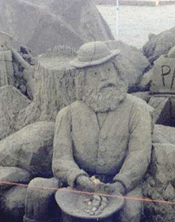 Sculpture of a bearded man sitting with something in his hands