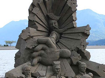 Abstract sand sculpture of a person reaching out of a hole, grasping to reach other people