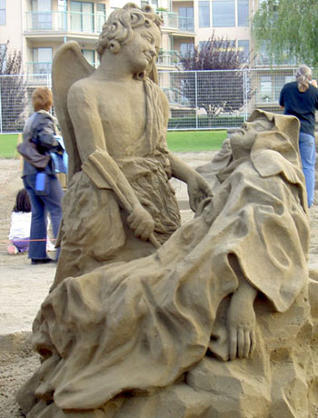 Sculpture of an angel staring lovingly at a sickly person