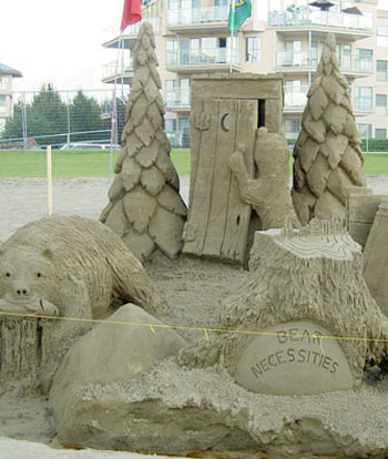 Abstract sculpture of an outhouse, bears, trees, a tree stump, and a stone reading: the Bear Necessities