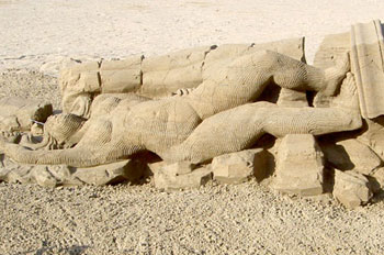 Sculpture of a woman lying naked on a pile of rocks