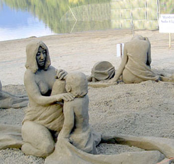 Sand sculpture of a women with her hand on a child's shoulder