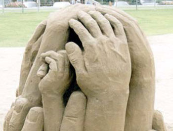 Abstract sand sculpture of hands holding each other