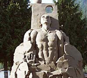 Sculpture made of sand that features a muscled man staring upward