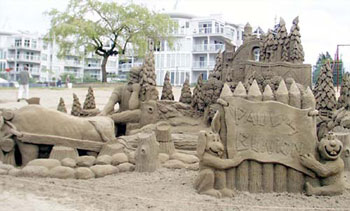 Sand Sculpture of two personified animals holding a sign, and a man resting uneasily in the background