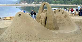 Sand sculpture of a two-faced person surrounded by a ring of faces