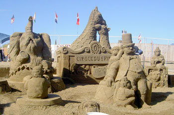 Sand sculpture of a circus including giraffes, an elephant, and people