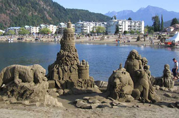 Sculpture made of sand depicting what appears to be an animal, a lion, a man, and a woman